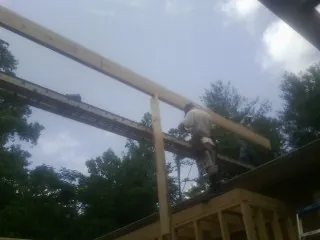 Carpenter setting a ridge beam over a new addition frame — Ice Dam Removal by Roofing Brothers in Red Feather Lakes