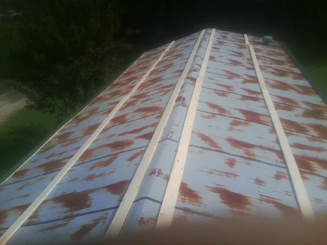 Rusted metal roof panels with new wood purlins before replacement — Storm Damage Roof Repair in Red Feather Lakes by Roofing Brothers