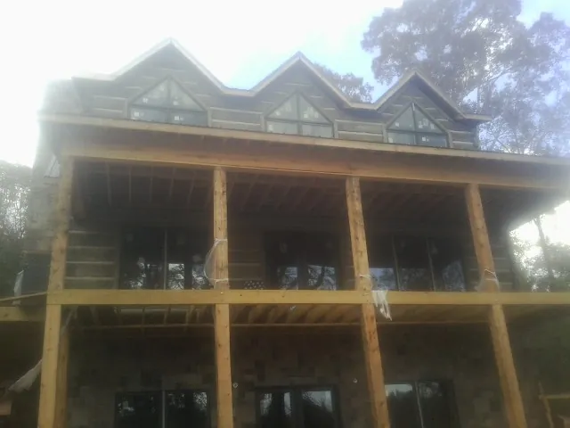 Dormers and porch framing on a large log home under construction — Roof Coating work by our crew in Red Feather Lakes