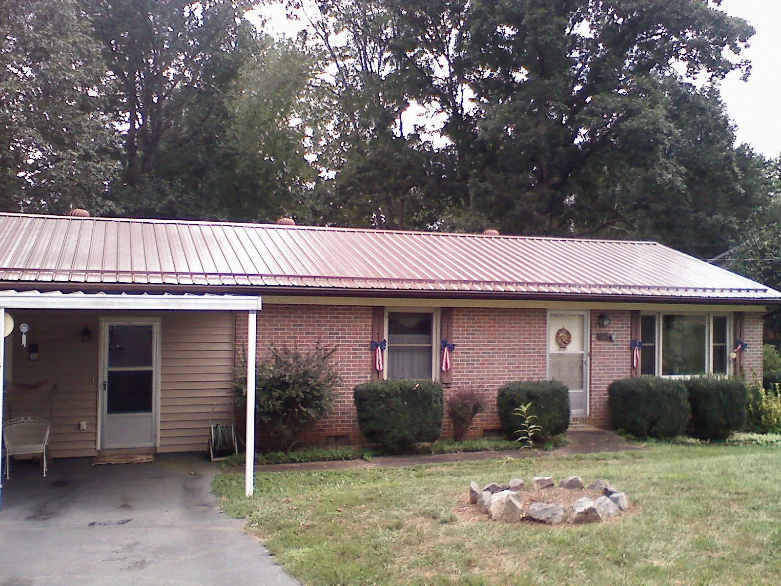 Bronze metal roof and carport on a brick ranch home — Roof Repair work by our crew in Red Feather Lakes